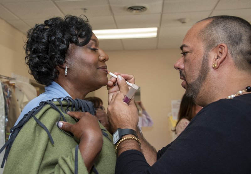 Percy VanOordt, right, puts the finishing touches on Angie Showell’s makeup.